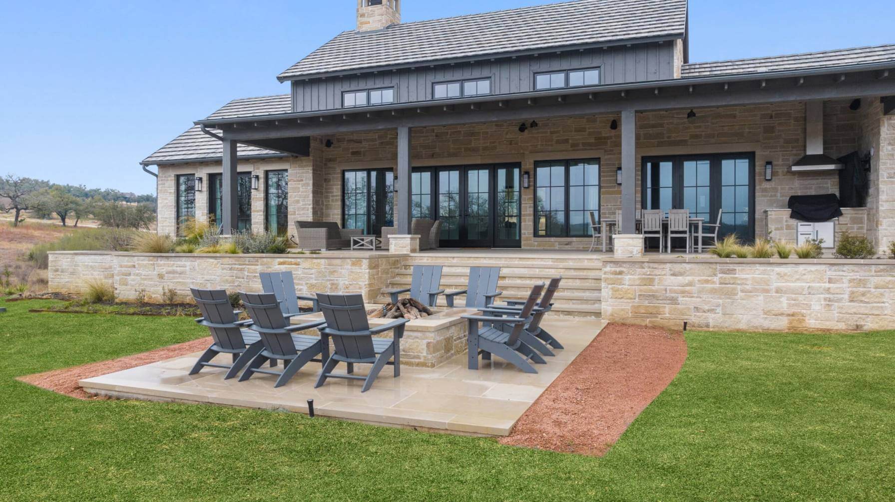 Newly built brick accented home with fire pit and chairs in Llano, Texas