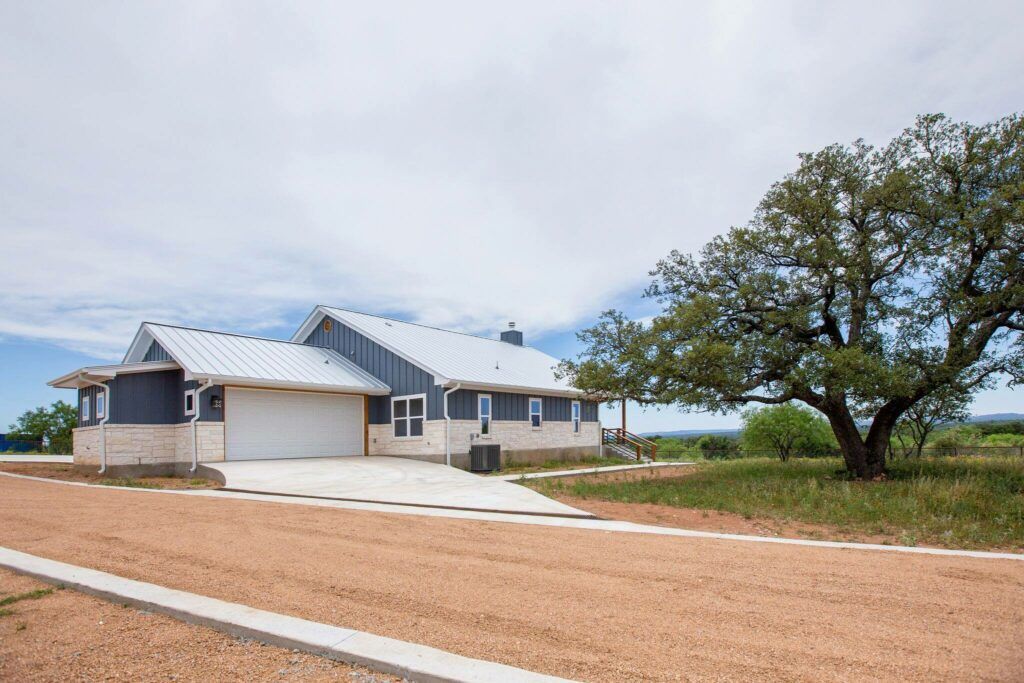 Mesquite Ranch house with a driveway and tree, located between Austin and Dallas, TX