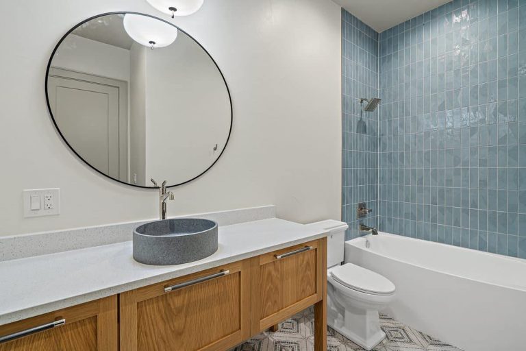 Granite Shoals Lodge bathroom featuring blue tile and a wood vanity in Austin and Dallas, TX.